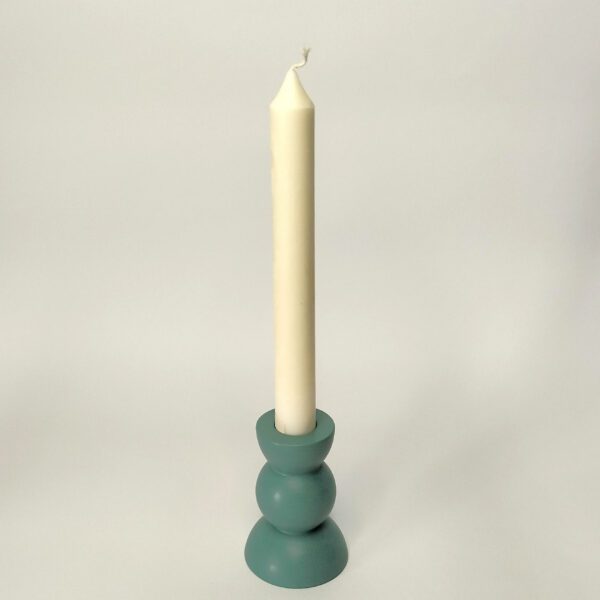 Castiçal Triesfera azul feito à mão em resina ecológica. Está exposto com uma vela fina dentro sobre um fundo branco.
