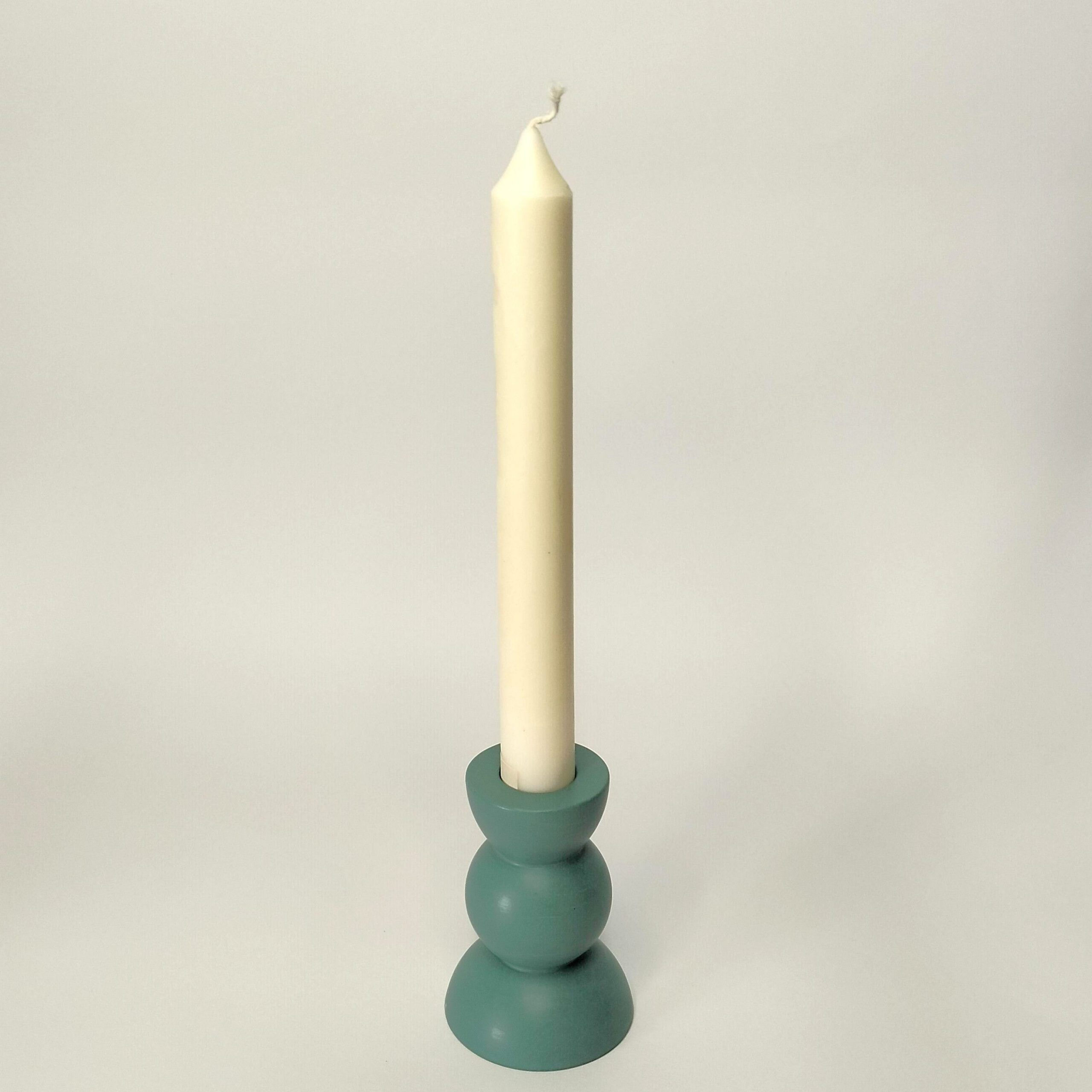 Castiçal Triesfera azul feito à mão em resina ecológica. Está exposto com uma vela fina dentro sobre um fundo branco.