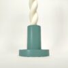 Castiçal cilíndrico azul, feito à mão em resina ecológica. Adequado para velas finas. Está exposto com uma vela branca torcida sobre um fundo branco.