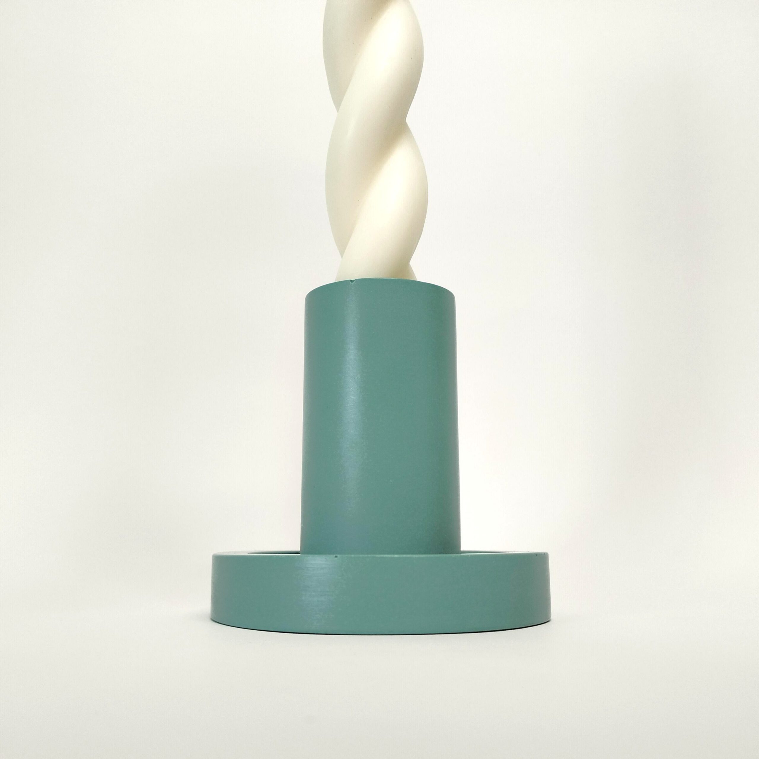Castiçal cilíndrico azul, feito à mão em resina ecológica. Adequado para velas finas. Está exposto com uma vela branca torcida sobre um fundo branco.