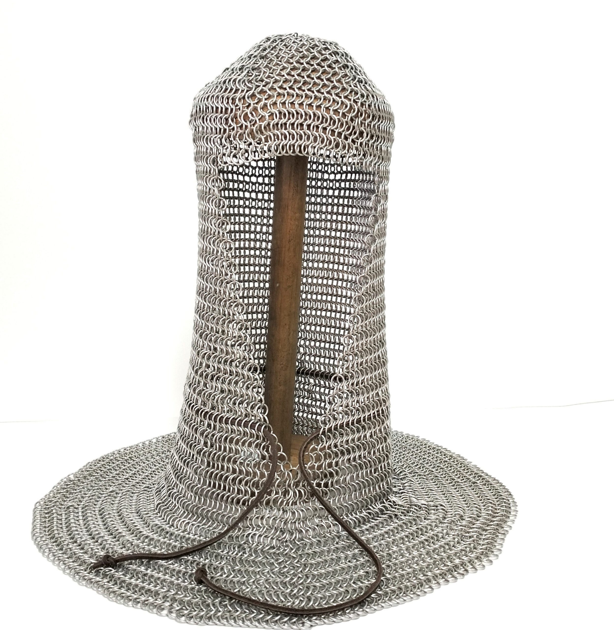 Camal artesanal em cota de malha em alumínio com cordão de couro. Está exposto num suporte de madeira próprio para o efeito, sobre um fundo branco.