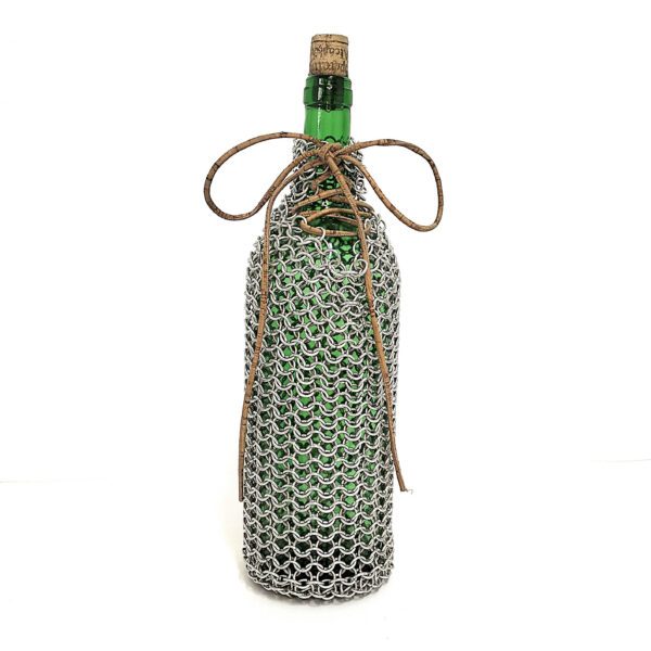 Capa artesanal para garrafa em cota de malha com fio de cortiça no gargalo. Está sobre um fundo branco.