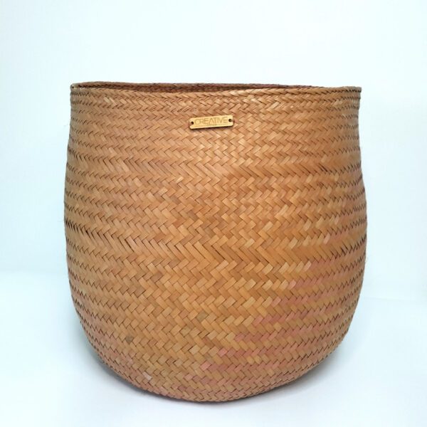 Cesta artesanal multiusos em folha de palma, cor de laranja e tamanho grande. Está sobre um fundo branco.