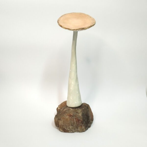 Cogumelo decorativo de cerâmica artesanal com base em pedra natural. Está exposto sobre um fundo branco.