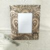 Moldura artesanal em madeira de manga pirogravada para fotografia de 10x10cm. Está sobre uma prateleira com um raminho de alfazema ao lado.