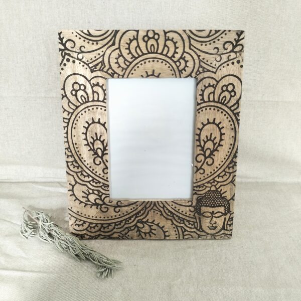 Moldura artesanal em madeira de manga pirogravada para fotografia de 10x10cm. Está sobre uma prateleira com um raminho de alfazema ao lado.