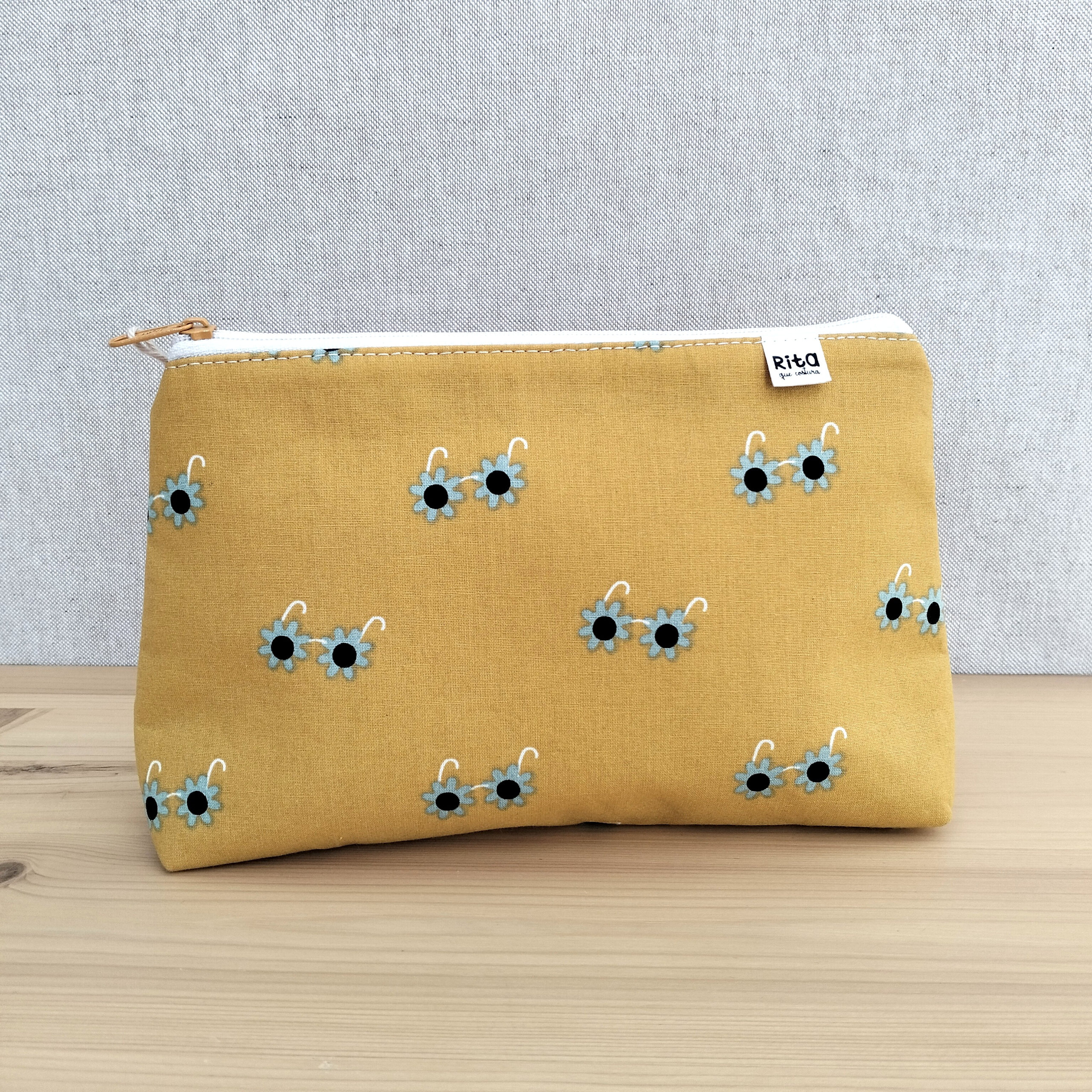 Bolsa amarela em tecido de algodão com fecho e padrão com óculos de sol em forma de flor.