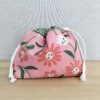 Bolsa rosa em tecido de algodão com cordão ajustável e padrão floral.