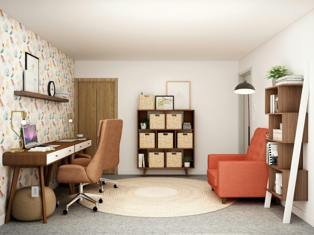 Imagem de escritório com três zonas definidas, uma de estudo ou trabalho com a secretária, outra ao fundo com uma estante com cestos de arrumação e outra do lado direito com um cadeirão, uma estante com livros e uma luz de apoio à leitura, parecendo uma pequena biblioteca.