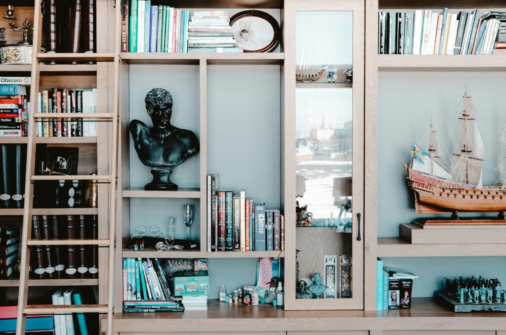 O exemplo de arrumação sem esconder tudo numa imagem de estante com várias peças decorativas cheias de personalidade que parecem contar a história de quem vive naquela casa.